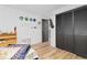 Bedroom featuring wood flooring and closet with black doors at 140 S Kendall St, Lakewood, CO 80226