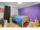 Bedroom with blue bed, wood flooring and purple accent wall at 140 S Kendall St, Lakewood, CO 80226