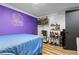 Bedroom with blue bed, wood flooring and purple accent wall at 140 S Kendall St, Lakewood, CO 80226