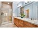 Bathroom featuring double sinks, a tiled shower with glass door, and warm neutral tones at 15501 E 112Th Ave # 33D, Commerce City, CO 80022