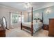 A well lit bedroom featuring a four poster bed, neutral carpeting, and a window at 15501 E 112Th Ave # 33D, Commerce City, CO 80022