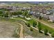 Aerial view of neighborhood with a playground, creek, and walking paths, with multiple homes and a residential building at 15460 Canyon Gulch Ln # 105, Englewood, CO 80112