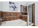Spa-like bathroom featuring a soaking tub and a separate shower with glass enclosure and decorative tile surround at 15460 Canyon Gulch Ln # 105, Englewood, CO 80112