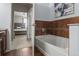 Primary bathroom featuring a bathtub with tile surround, and an adjacent bedroom with a view to the exterior at 15460 Canyon Gulch Ln # 105, Englewood, CO 80112
