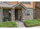 Apartment entrance featuring stone details, concrete stairs and wrought iron handrails and landscaping at 15460 Canyon Gulch Ln # 105, Englewood, CO 80112