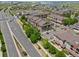 Aerial view of residential buildings near a road with sidewalk and grass landscape with a residential neighborhood behind at 15460 Canyon Gulch Ln # 105, Englewood, CO 80112