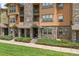 Apartment building exterior featuring stone accents, covered porch entries and green lawn at 15460 Canyon Gulch Ln # 105, Englewood, CO 80112