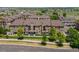 Low aerial view of a three story residential building surrounded by road and sidewalk, in neighborhood at 15460 Canyon Gulch Ln # 105, Englewood, CO 80112