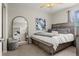 Relax in this serene bedroom with stylish decor, comfortable bed and an open doorway to the living room at 15460 Canyon Gulch Ln # 105, Englewood, CO 80112