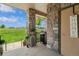 Covered patio with stone columns and grill, ideal for outdoor entertaining with serene views of the green space at 15460 Canyon Gulch Ln # 105, Englewood, CO 80112