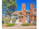 Charming townhome featuring a brick chimney, cozy front porch, and well-manicured landscaping at 2862 W Long Dr # A, Littleton, CO 80120