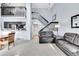 Open-concept living room with soaring ceilings, a cozy sofa, and stairs leading to the upper level at 2862 W Long Dr # A, Littleton, CO 80120