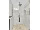 Modern glass shower with stone tile, rain shower head, and inset shelf at 2862 W Long Dr # A, Littleton, CO 80120