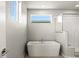 Spa-like bathroom featuring a modern soaking tub and windows for natural light at 2662 E 103Rd Ave, Thornton, CO 80229