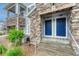 Close-up of a townhouse entry with blue doors, stone accents, and well-maintained landscaping at 5255 Memphis St # 1009, Denver, CO 80239