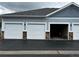 Exterior view of garages with white doors and a paved driveway at 5255 Memphis St # 1009, Denver, CO 80239