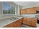 Well-lit kitchen with granite countertops, stainless steel appliances, and wood cabinets at 5255 Memphis St # 1009, Denver, CO 80239