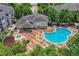Aerial view of pool and hot tub with lounge chairs surrounded by lush landscaping at a community clubhouse at 5255 Memphis St # 1009, Denver, CO 80239