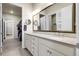 Bright bathroom with double sinks, large mirrors, and a view into an organized walk-in closet and calming, neutral tones at 25059 E Alder Dr, Aurora, CO 80016