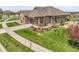 Charming home with a well-manicured lawn, colorful landscaping, and a welcoming, stone-accented facade at 25059 E Alder Dr, Aurora, CO 80016