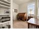 Charming home office featuring a beautiful rolltop desk, natural light, and built-in shelves for storage and display at 25059 E Alder Dr, Aurora, CO 80016