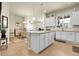 Spacious kitchen with a center island, white cabinets, and seamless access to the dining and living areas at 25059 E Alder Dr, Aurora, CO 80016