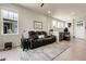 Inviting living room featuring a comfortable leather sofa, light wood floors, and an abundance of natural light at 25059 E Alder Dr, Aurora, CO 80016