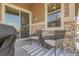 Cozy patio area with stylish wicker furniture and sliding glass door access to the home's interior at 25059 E Alder Dr, Aurora, CO 80016