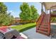 Backyard view featuring a wooden staircase leading to lush lawn, and mature trees at 4920 S Netherland Way, Centennial, CO 80015