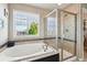 Bright bathroom with a soaking tub, glass enclosed shower, and a large window with a view at 4920 S Netherland Way, Centennial, CO 80015