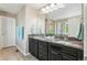 Double sink bathroom featuring granite countertops, dark cabinetry, and tiled flooring at 4920 S Netherland Way, Centennial, CO 80015