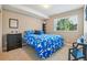 Comfortable bedroom features a bright blue floral bedspread and a view from the window at 4920 S Netherland Way, Centennial, CO 80015