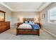This main bedroom offers a wooden bedframe, bedside tables, and a window for natural lighting at 4920 S Netherland Way, Centennial, CO 80015