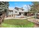 Wide backyard showcasing a lush lawn, stone patio with an outdoor fireplace, pergola, and well-maintained landscaping at 10629 W Glasgow Ave, Littleton, CO 80127