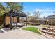 Landscaped backyard with pergola-covered seating area, stone pathway, water feature, and playhouse at 10629 W Glasgow Ave, Littleton, CO 80127