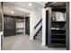Hallway with two doors, stairs, a built-in bookshelf, and grey floors at 10629 W Glasgow Ave, Littleton, CO 80127