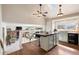 Bright kitchen featuring white cabinetry, a mosaic tile backsplash, a large island with wood countertop, and modern appliances at 10629 W Glasgow Ave, Littleton, CO 80127