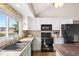 Bright kitchen featuring white cabinetry, a mosaic tile backsplash, a large island with wood countertop, and modern appliances at 10629 W Glasgow Ave, Littleton, CO 80127