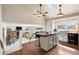 Open kitchen with island, skylight, modern cabinets, and hardwood floors, with view into Gathering room at 10629 W Glasgow Ave, Littleton, CO 80127