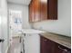 Functional laundry room with updated appliances, wood countertop, and adjacent access to a bathroom at 10629 W Glasgow Ave, Littleton, CO 80127