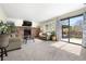 Cozy living room with a brick fireplace, plush seating, and sliding glass doors to the backyard patio at 10629 W Glasgow Ave, Littleton, CO 80127