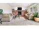 Cozy living room with a brick fireplace, plush seating, and a large window for natural light at 10629 W Glasgow Ave, Littleton, CO 80127
