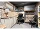 Stylish office space featuring exposed brick, custom shelving, a guitar, and comfortable seating at 10629 W Glasgow Ave, Littleton, CO 80127
