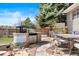 Outdoor kitchen featuring built-in grill, fire pit, dining area, and beautiful landscaping at 10629 W Glasgow Ave, Littleton, CO 80127