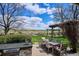 This large backyard features an outdoor kitchen, dining table and chairs under a pergola with a beautiful view at 4358 S Alton St, Greenwood Village, CO 80111