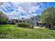 The backyard features a stone patio, lush grass, and the rear exterior of the house with gray siding at 4358 S Alton St, Greenwood Village, CO 80111