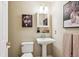 Bathroom featuring a pedestal sink, wall art, overhead lighting, and a framed mirror at 4358 S Alton St, Greenwood Village, CO 80111