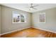 Empty bedroom with two windows, wood floors and neutral paint, bathed in natural light at 4358 S Alton St, Greenwood Village, CO 80111