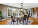 This dining room offers a large window for natural light, a six-seat wooden dining table, and hardwood flooring at 4358 S Alton St, Greenwood Village, CO 80111