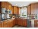 Stylish kitchen with stainless steel appliances, wood cabinets, modern backsplash, and ample counter space at 4358 S Alton St, Greenwood Village, CO 80111